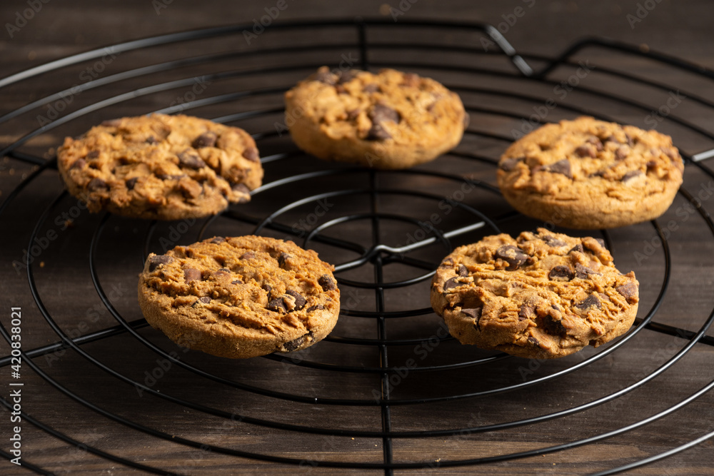 Top view of chocolate chip cookies on black rack, with selective focus, on wooden table, horizontal Top view of chocolate chip cookies on black rack, with selective focus, on wooden table, horizontal