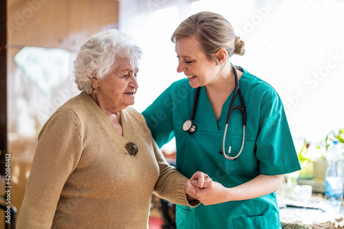 Friendly nurse supporting an elderly lady
 photo