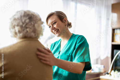 Fotografia Friendly nurse supporting an elderly lady