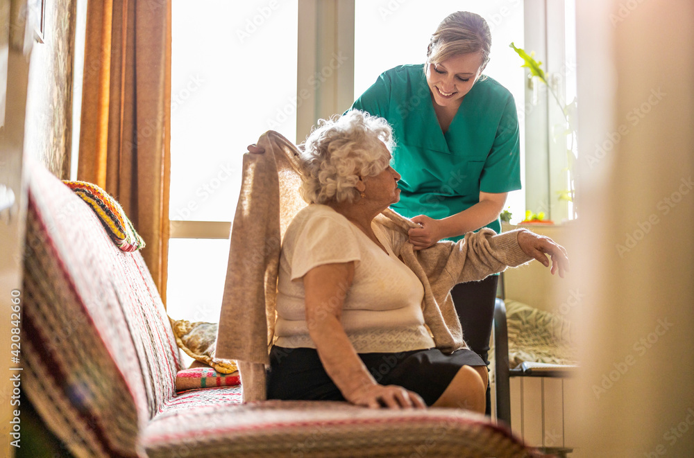 Female nurse taking care of a senior woman at home
 - obrazy, fototapety, plakaty 