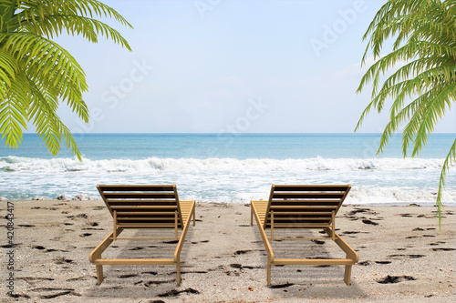 Summer photo with a beautiful clean beach, sun loungers and hanging palm trees. Summer concept