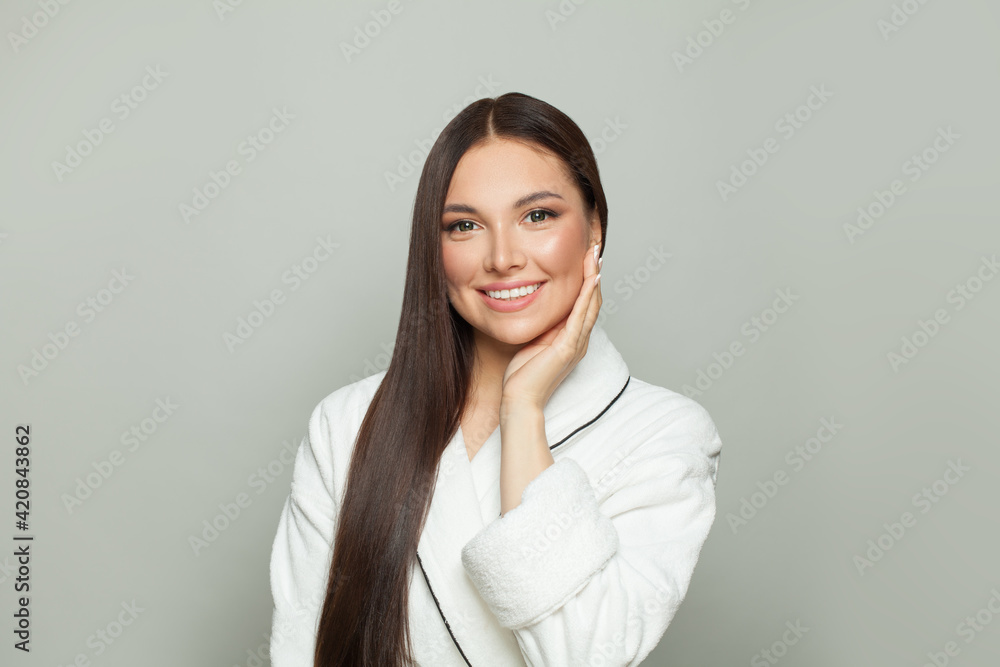 Healthy spa woman with clear skin and dark long straight hair on white background. Young female model smiling. Haircare and facial treatment concept Healthy spa woman with clear skin and dark long straight hair on white background. Young female model smiling. Haircare and facial treatment concept