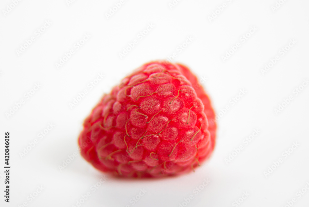 One ripe raspberry isolated on white background. Close up view One ripe raspberry isolated on white background. Close up view