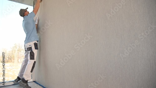 Canvas Textured Vinyl Wallpaper Installation with Squeegee Tool. Apartment Remodeling. photo