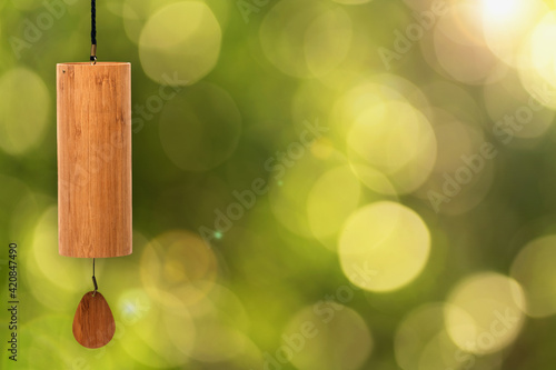 Close-up of a hand made Koshi chime musical instrument made from bamboo against an attractive blurred natural background with creamy bokeh and narrow depth of field. Copy space. photo