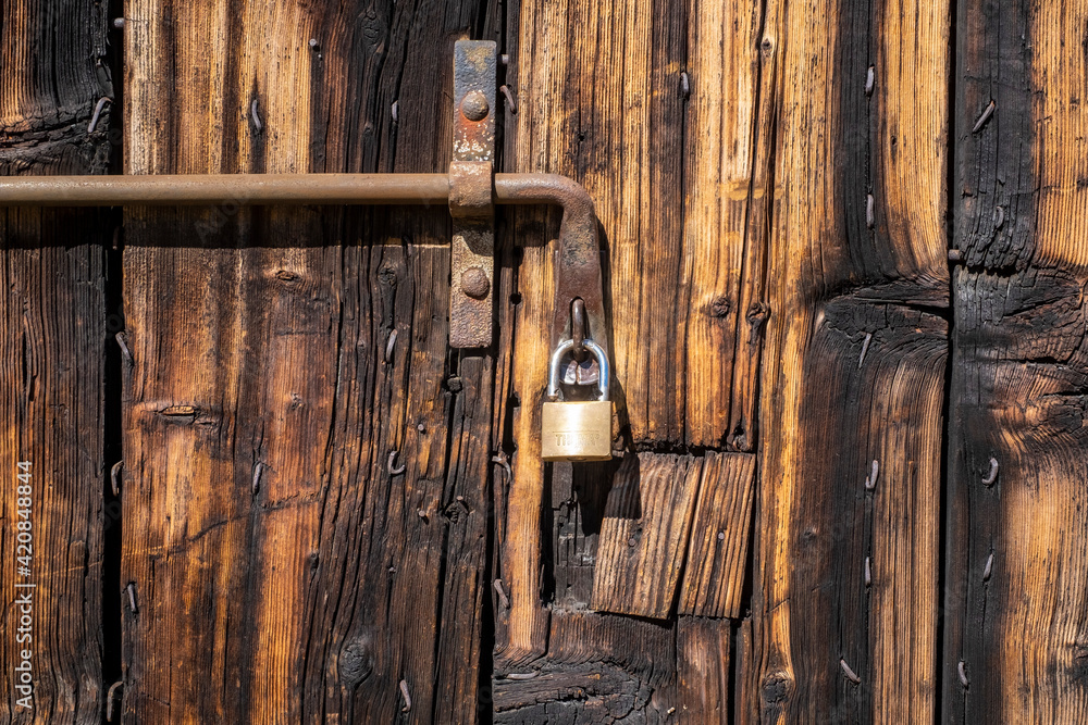 Italy, Wooden door with padlock, door with various colors and a background with old wood as a texture. Italy, Wooden door with padlock, door with various colors and a background with old wood as a texture.