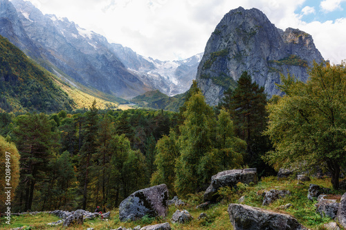 A tourist surrounded by an autumn mountain range. Ossetia Tsey