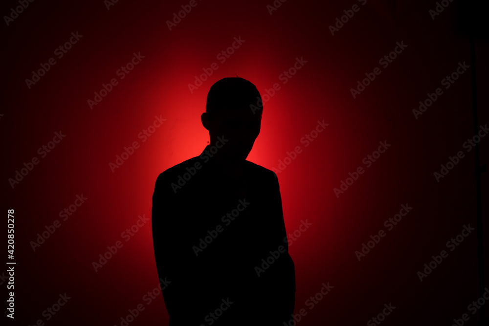 Silhouette of a man on a red background.