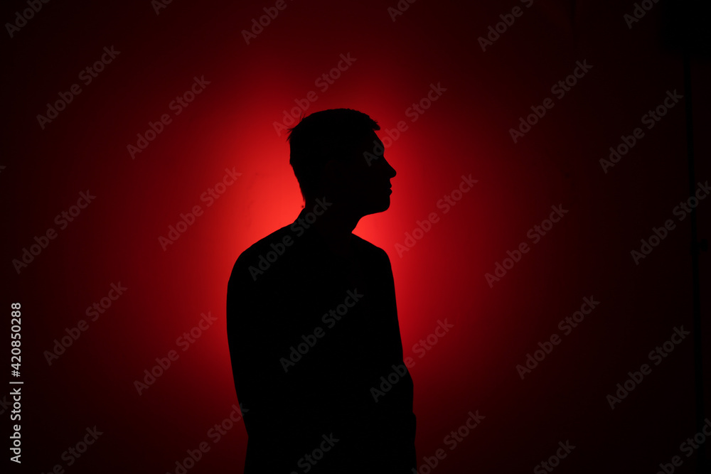 Silhouette of a man on a red background.