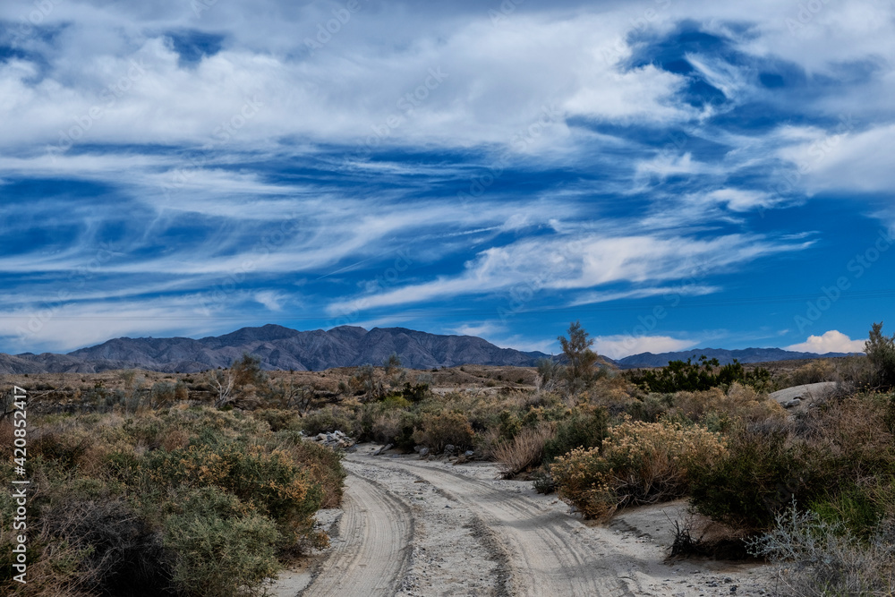 Desert road toward mountains with deep blue California sky