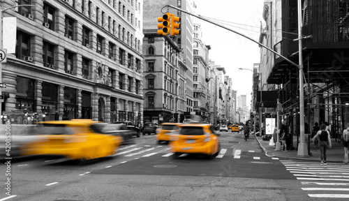 Yellow taxis driving down the street isolated on black and white view of New York City NYC