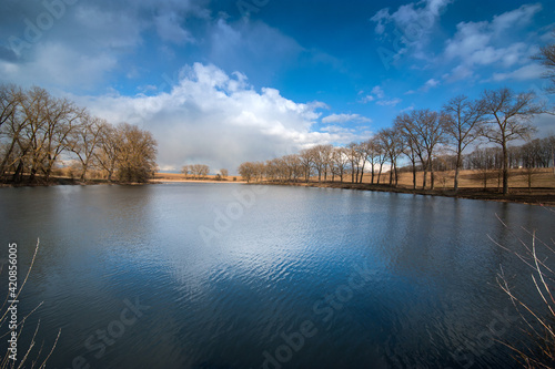 Beautiful panoramic landscape on a pond and the reflection of reeds, sky and ...