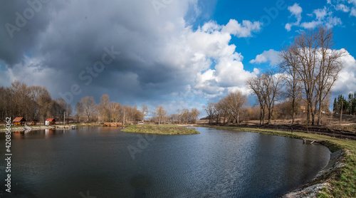 landscape with pond and reflection in water trees, beautiful sky, at early sp...