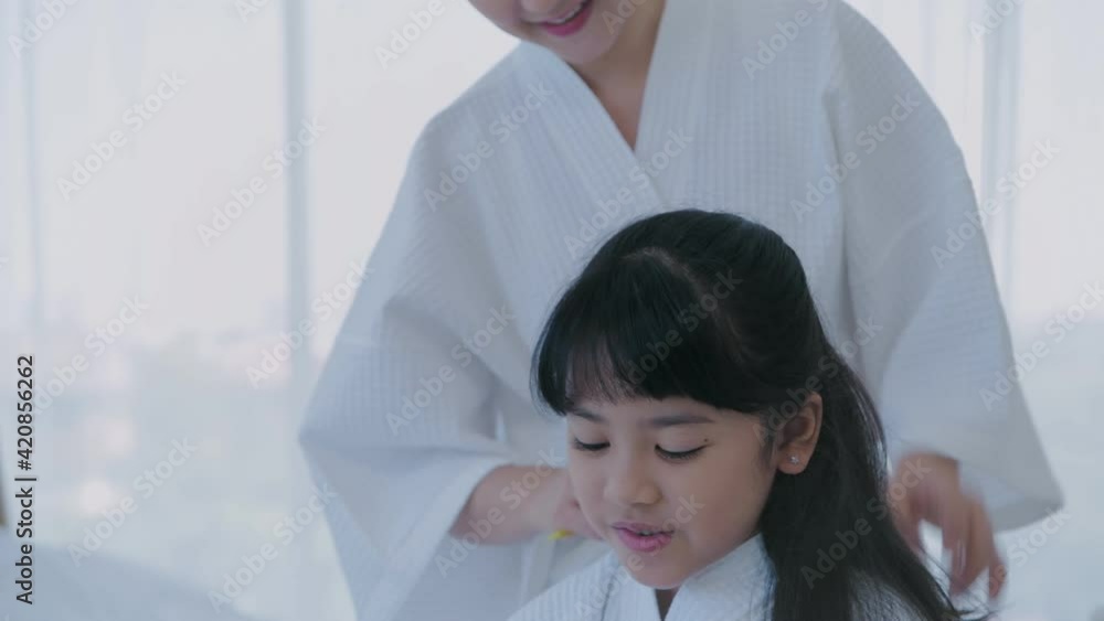 Spa concept of 4k Resolution. Mom combing her hair for daughter in bedroom. Spa concept of 4k Resolution. Mom combing her hair for daughter in bedroom.