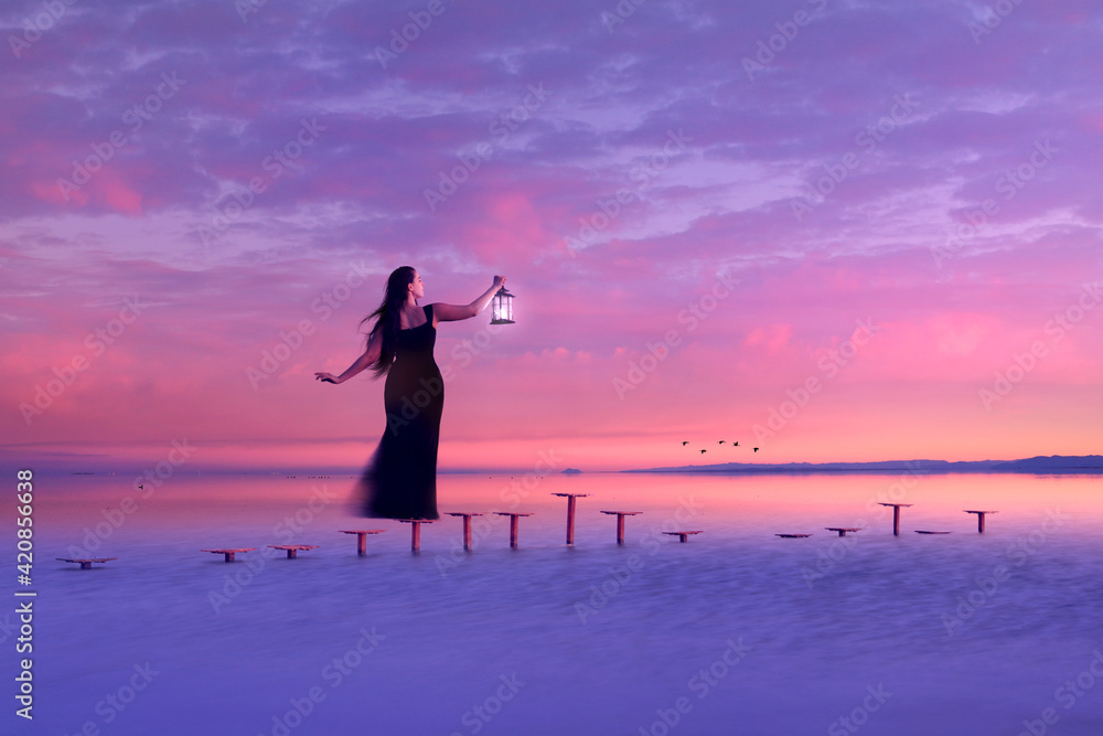 Fototapeta premium Girl Looking Out to Sea Holding Lantern