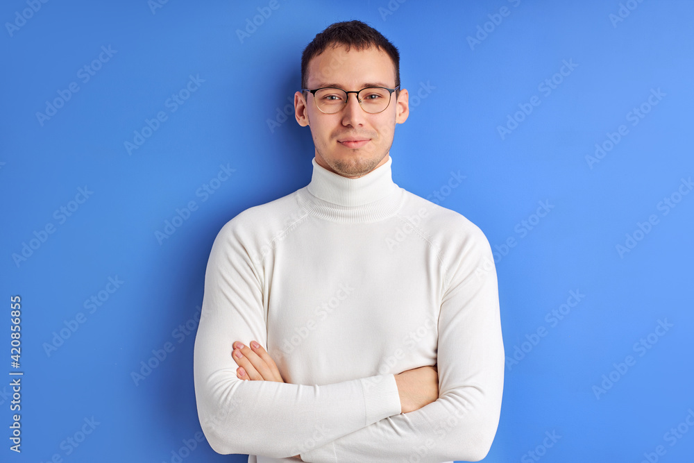 Young businessman in spectacles posing looking at camera with arms folded Young businessman in spectacles posing looking at camera with arms folded