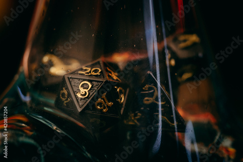 Dungeons and Dragons Dice - Metal D20 in red light by flames and glass for roleplay games as Pathfinder, Warhammer, Vampire the Masquerade, 7th Sea and Savage Word