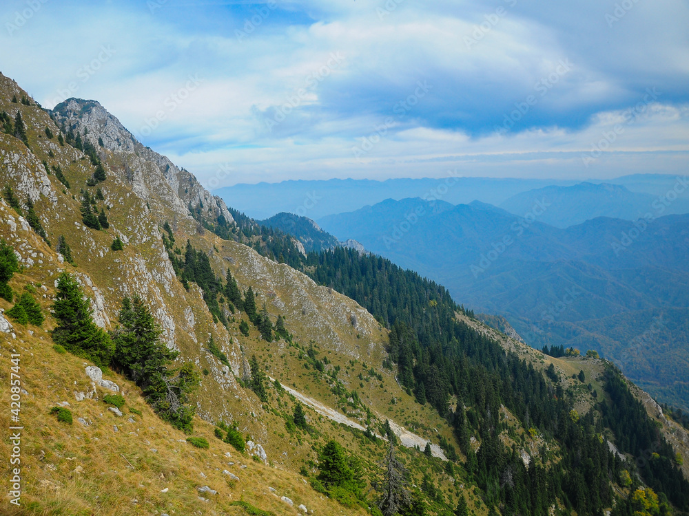 Photo taken from the abrupt crests of Buila Mountains. Calcareous cliffs populate the abrupt mountain sides of the Massif. Carpathia, Romania.