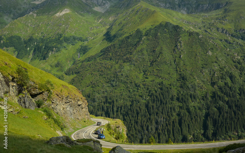 Transfagarasan road winding along Fagaras Mountains high altitude crests. A sinuous curve bypasses a sharp cliff and winds near a steep abyss. Carpathia, Romania.