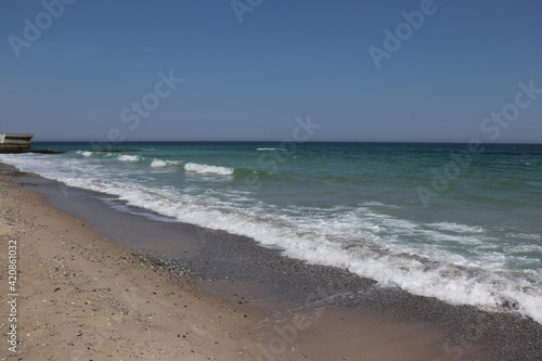 Black undulating sea in Odessa on a sunny warm day.