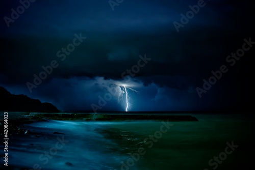 Thunderstorm and storm at sea. Lightning struck the water. © Sergey