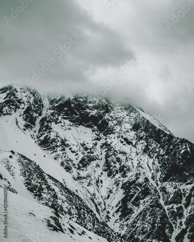 Snowy Mountain Peak Covered By Clouds  photo