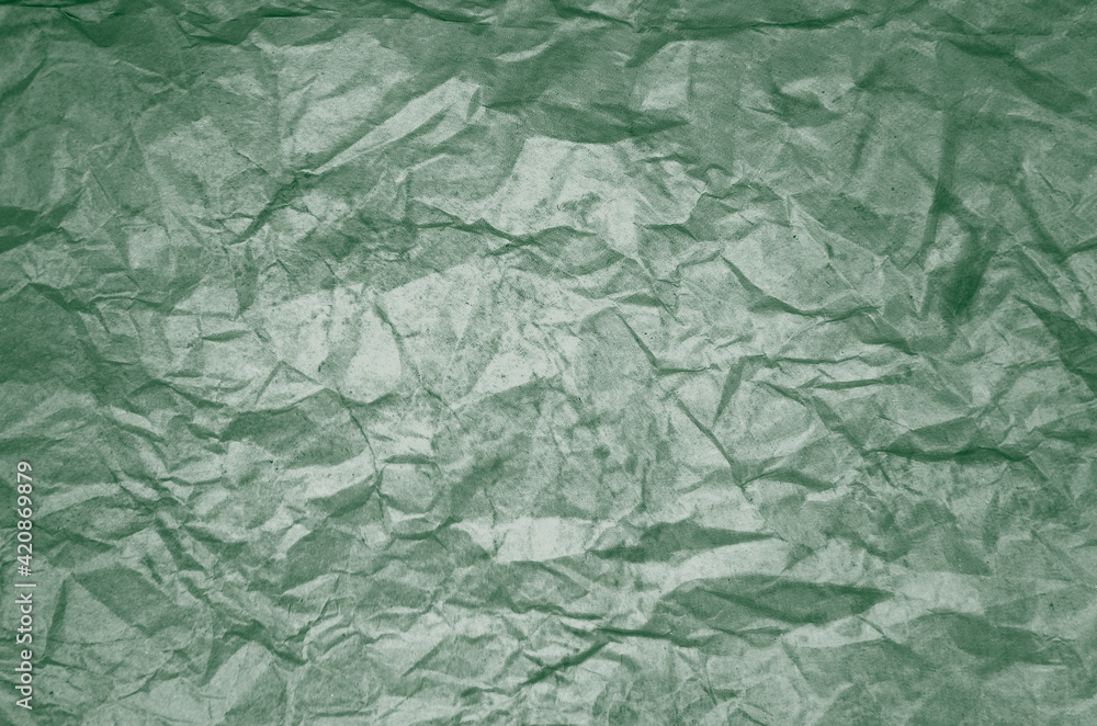 Dirty texture of old crumpled green paper. Wrinkled texture of colored packaging. St Patricks Day abstract background.