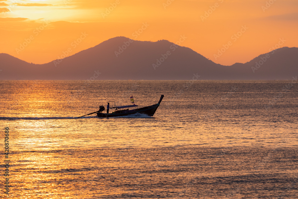 Ein Boot im Sonnenuntergang mit Bergen im Hintergrund