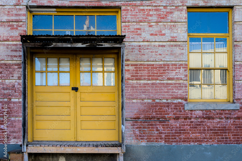 Naklejka premium Yellow doors, brick building