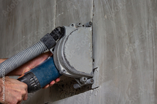cutting a wall with a power tool at a construction site using a vacuum cleaner