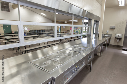 School Cafeteria empty and closed due to Covid-19 pandemic. Stainless steel serving counter.