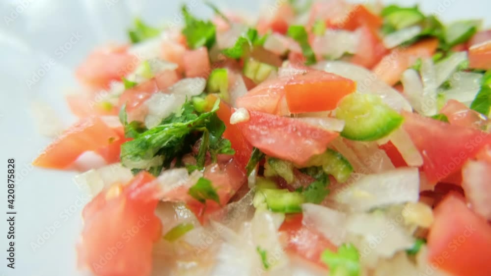 Chopped tomato, onion, and chili pepper on white plate Chopped tomato, onion, and chili pepper on white plate