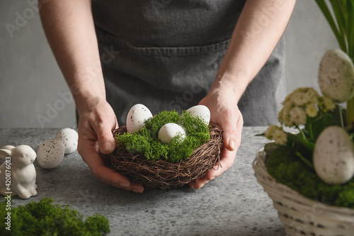 Easter floral composition for table centerpiece with festive white eggs, moss and bunny. Floral spring workshop. photo