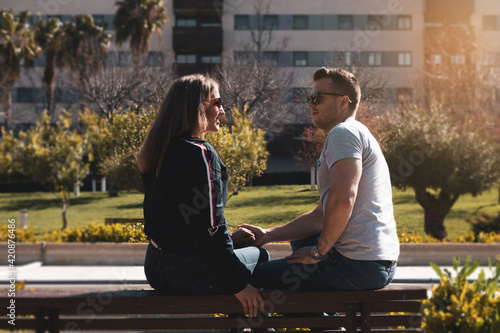 couple sitting on a bench posing romantically photo