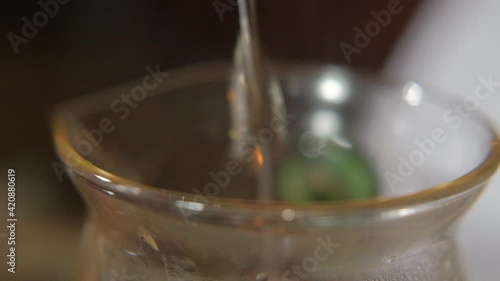 Teamaster begins the classical Chinese tea ceremony. Warms up the kettle for the ceremony. Pours water into a kettle and brews Chinese tea. Pours tea through a strainer. Authentic tea paraphernalia. photo