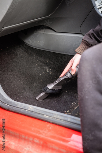 Someone vacuum cleaning out the inside of the car.