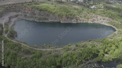 Granite quarry lake with a lot of green trees around