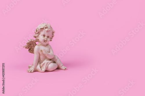 Minimal creative idea with a white angel on a pink background. © Jovica Varga