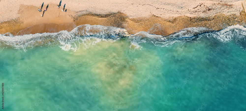 Empty tropical sand beach and azure sea or ocean water aerial top view from drone, panoramic long banner with copy space. Empty tropical sand beach and azure sea or ocean water aerial top view from drone, panoramic long banner with copy space.