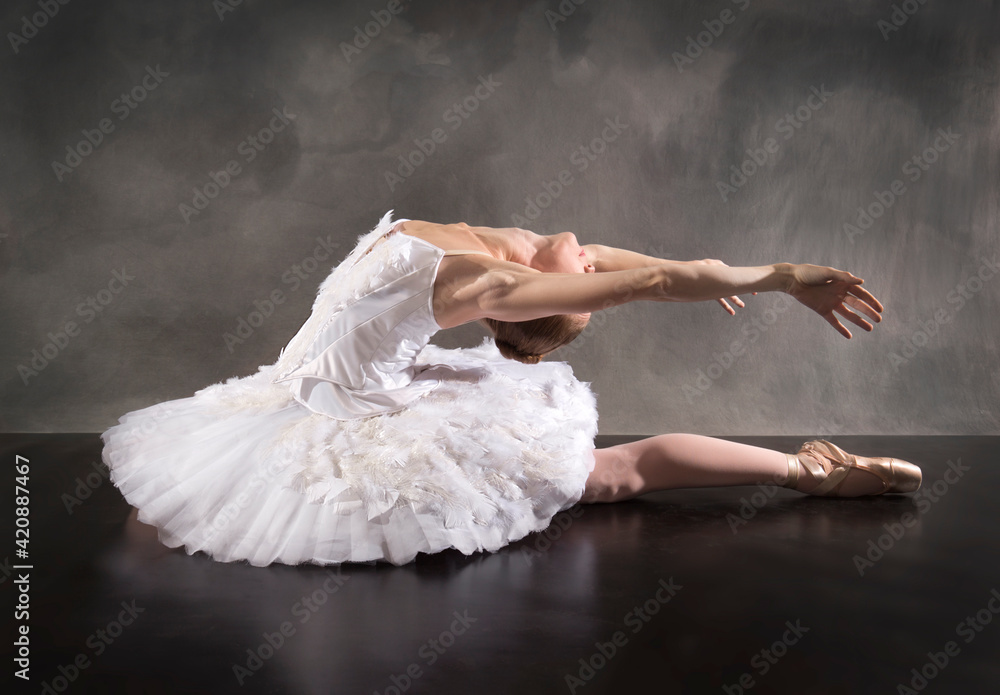 Naklejka premium Ballerina in white tutu, leaning back like a swan.