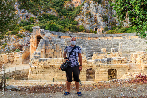 Tourist wearing medical face mask in ancient city of Myra in Demre, Antalya province in Turkey. Concept of traveling during pandemic and personal protection