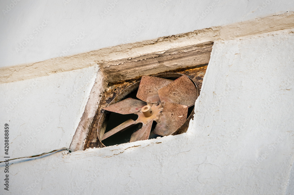 Fan with engine mounted in a stucco wall, large fan blades rotate Stock ...