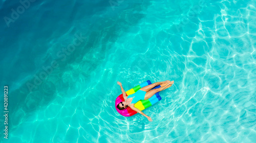 Aerial view. Beautiful woman wearing blue bikini relaxing on an air mattress . A sexy young girl. Holiday person. Amazing sea nature background.