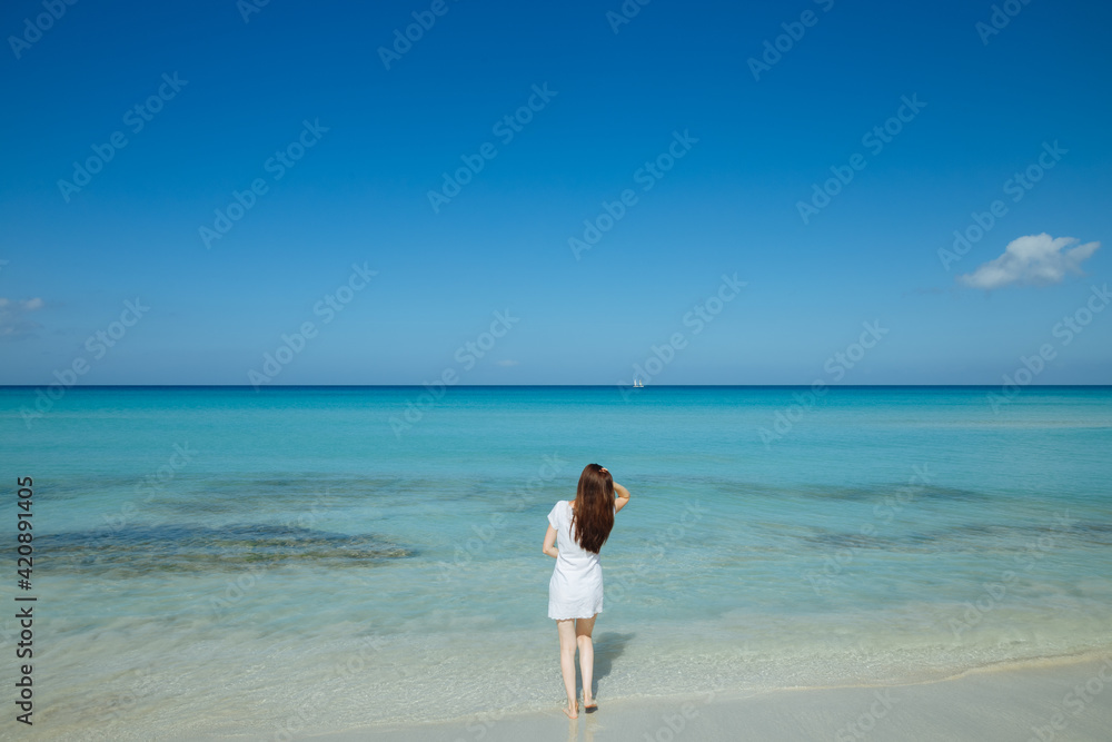 Beautiful thin woman is running along the beach. Heavenly sea in beautiful teal color. Sea in Cuba. Model on the beach Beautiful thin woman is running along the beach. Heavenly sea in beautiful teal color. Sea in Cuba. Model on the beach