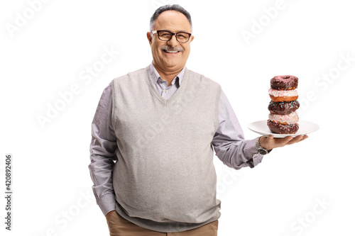 Smiling mature man holding a plate of chocolate donuts