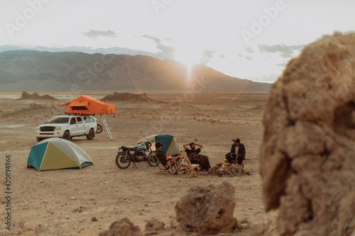 Motorcyclist road trippers around camp fire, Trona Pinnacles, California, US