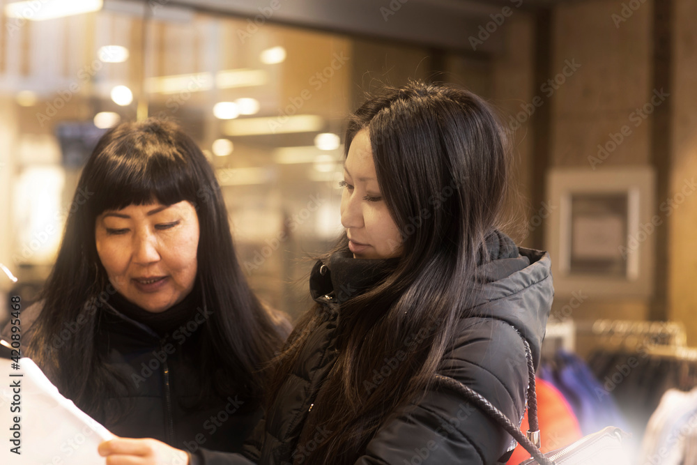 Mother and daughter window shopping at Christmas market, Freiburg, Baden-Wurttemberg, Germany Mother and daughter window shopping at Christmas market, Freiburg, Baden-Wurttemberg, Germany
