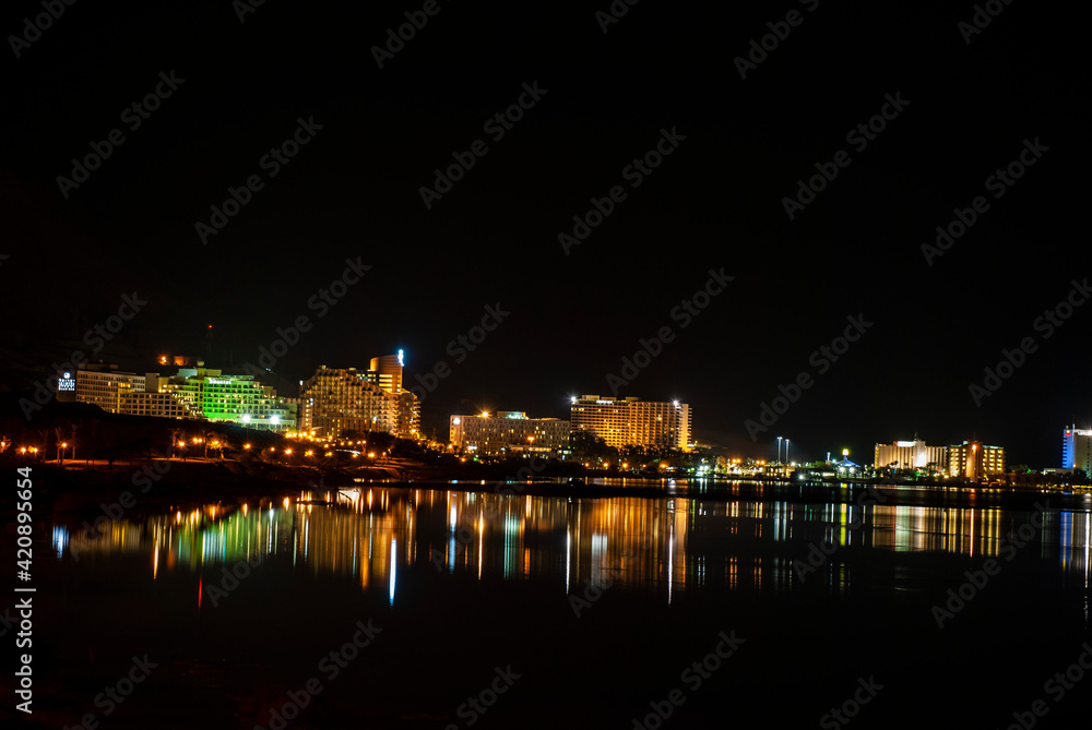 Illuminated hotels, with light reflecting in the Dead Sea at night, Ein Bokek, Israel (view from south) Illuminated hotels, with light reflecting in the Dead Sea at night, Ein Bokek, Israel (view from south)