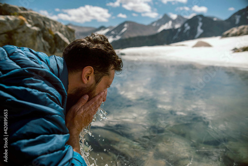 Hiker freshening up at lake, Mineral King, California, United States