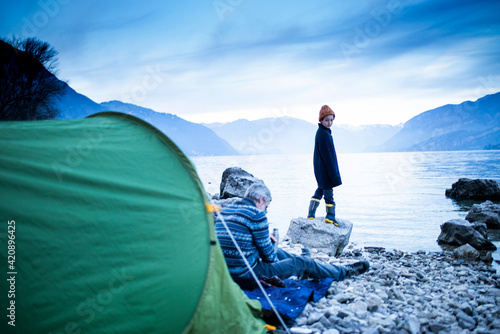 Father and son camping by lakeside, Onno, Lombardy, Italy